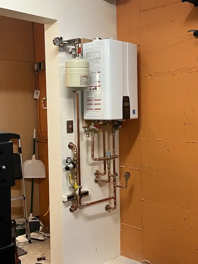 Plumbing technician inspecting water heater connections in Odessa
